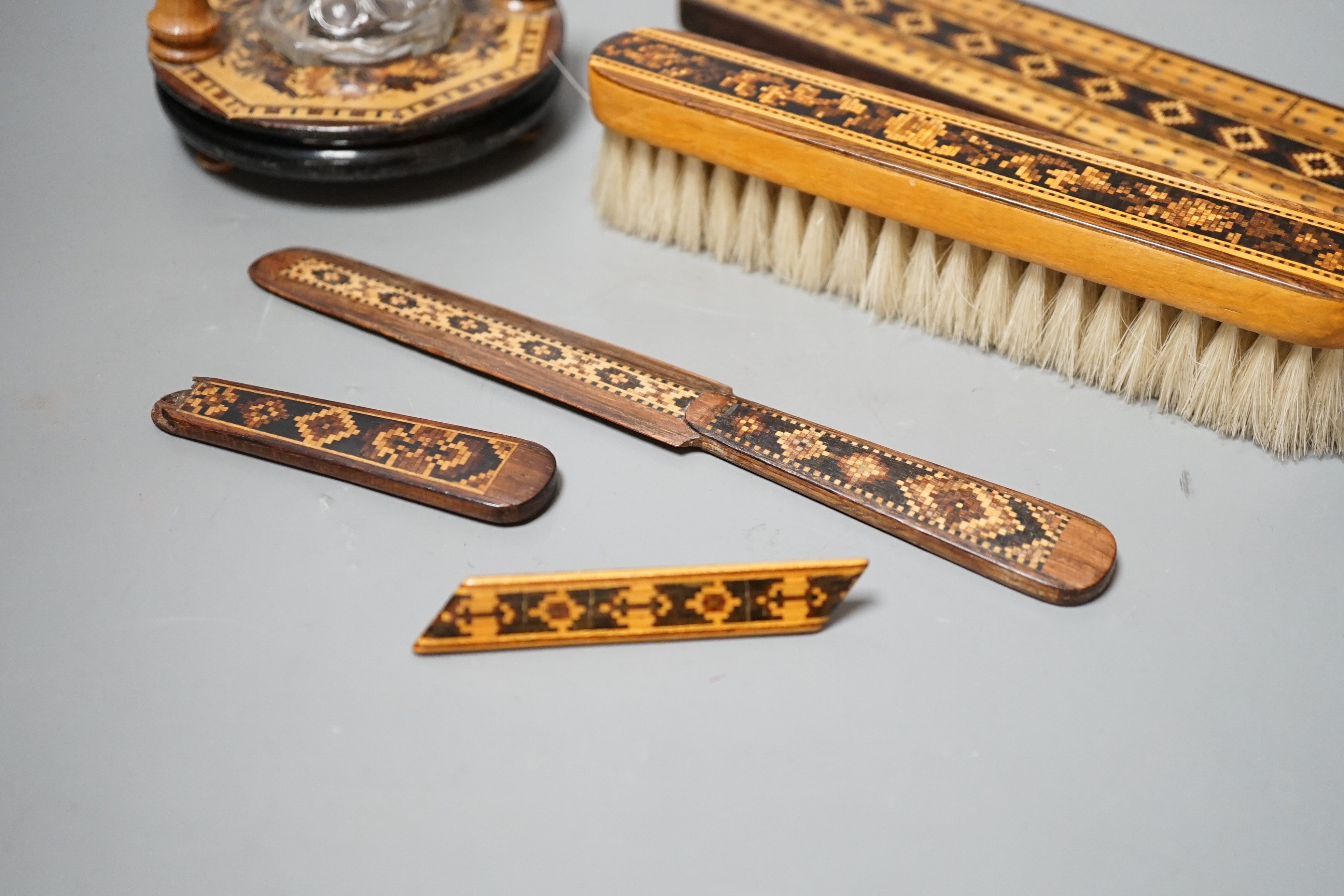 A group of Tunbridge ware to include an inkstand, two paper knives (one a handle only), cribbage board, a brush and a brooch